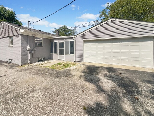 4013 N Graham Ave, Indianapolis, IN 46226 - rear view of property with brick siding, a chimney, driveway, and a garage