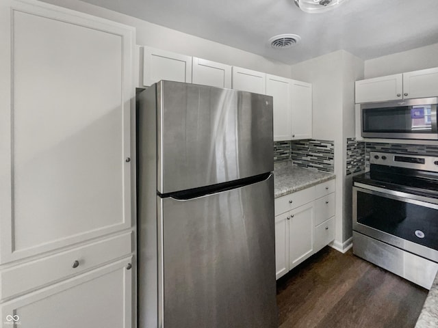 4013 N Graham Ave, Indianapolis, IN 46226 - kitchen featuring appliances with stainless steel finishes, dark wood-style floors, tasteful backsplash, and white cabinets