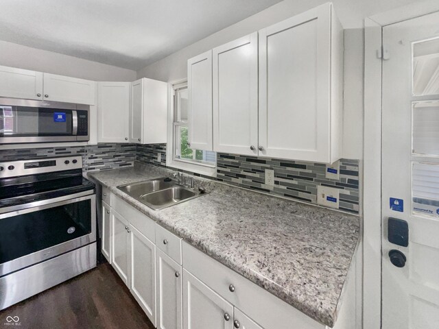 4013 N Graham Ave, Indianapolis, IN 46226 - kitchen featuring appliances with stainless steel finishes, a sink, white cabinetry, and backsplash