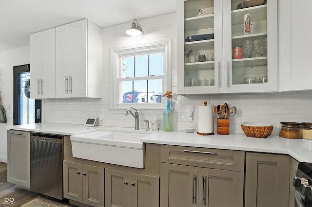 kitchen featuring stainless steel dishwasher, sink, dark wood-type flooring, and backsplash