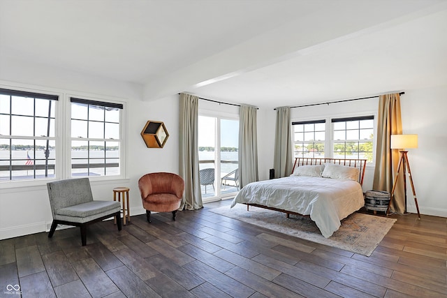 bedroom featuring beam ceiling, dark hardwood / wood-style flooring, and access to exterior