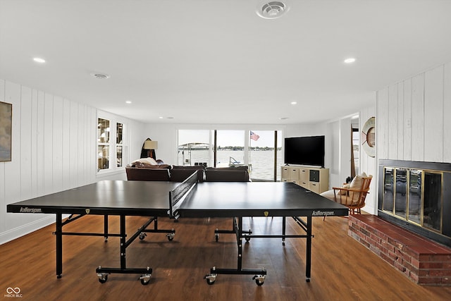 game room with a fireplace and dark hardwood / wood-style flooring