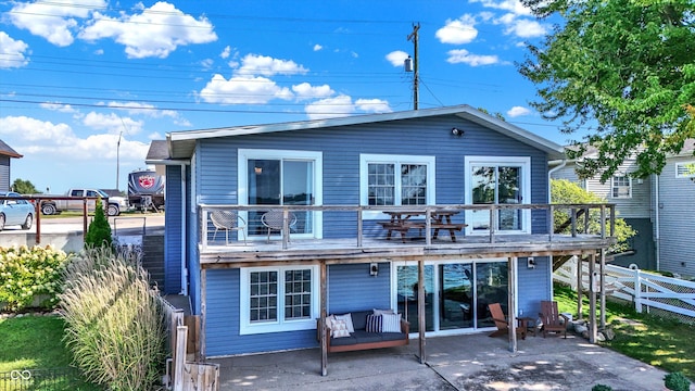 rear view of house featuring a patio area, an outdoor hangout area, and a balcony