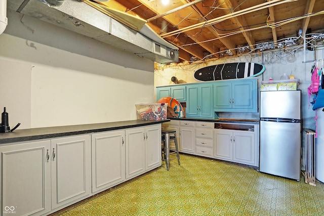 interior space featuring stainless steel fridge, white cabinetry, and light tile patterned floors