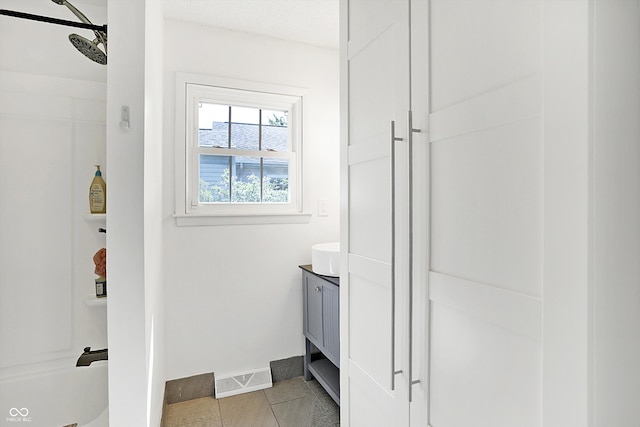 bathroom featuring a shower, tile patterned flooring, and vanity