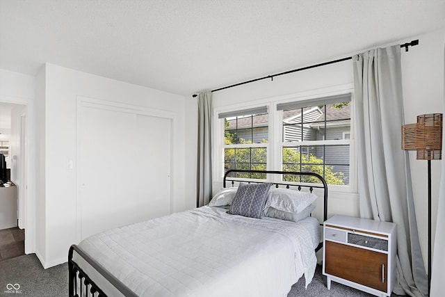 bedroom with a closet, a textured ceiling, and carpet flooring