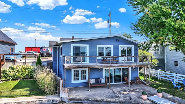 back of house with a lawn, a patio area, and a deck