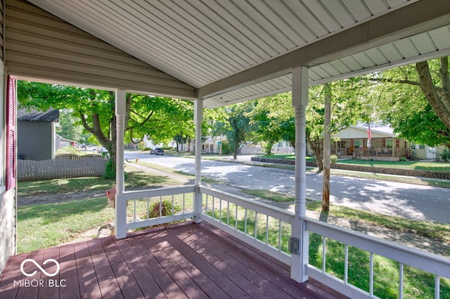 wooden terrace with a lawn and a porch