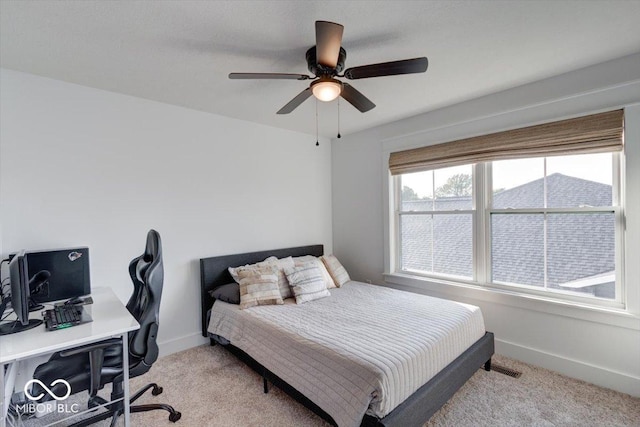 bedroom with baseboards, ceiling fan, and light colored carpet