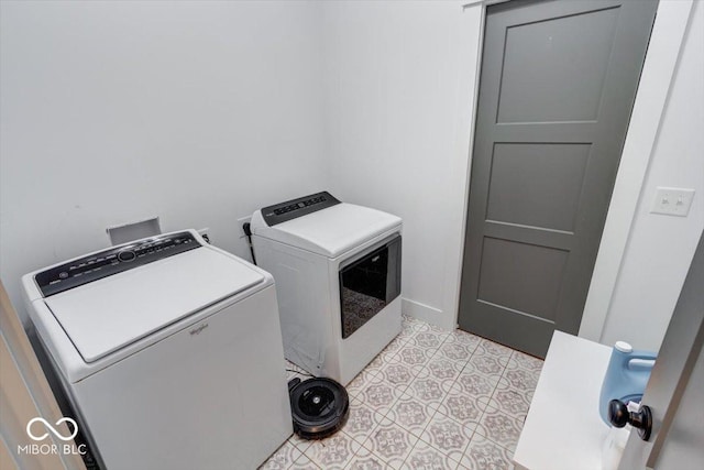 laundry area featuring laundry area, washing machine and dryer, and light tile patterned floors