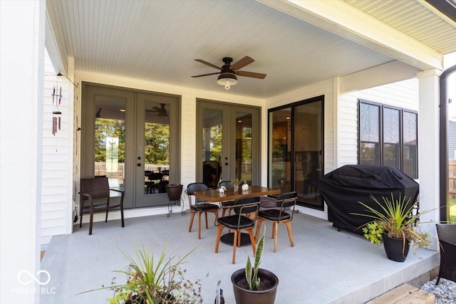 view of patio featuring a ceiling fan, outdoor dining area, area for grilling, and french doors