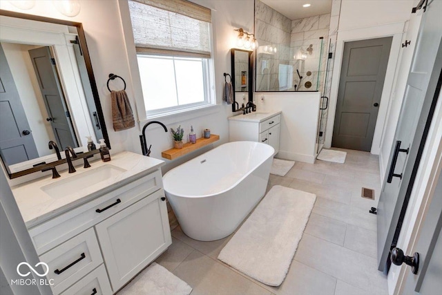 full bathroom with a soaking tub, two vanities, a sink, a shower stall, and tile patterned floors