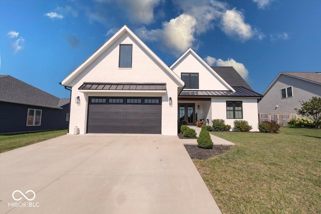 modern farmhouse featuring metal roof, brick siding, concrete driveway, a front lawn, and a standing seam roof