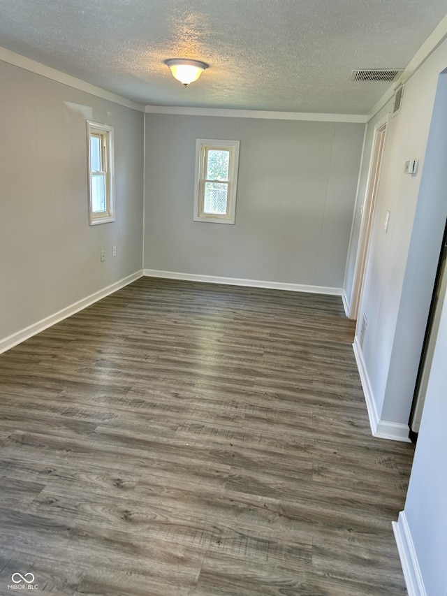 empty room with visible vents, baseboards, and dark wood-style flooring