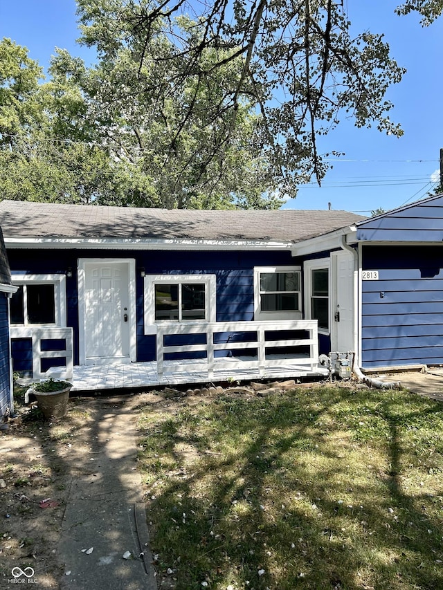 ranch-style house featuring a wooden deck and a front yard