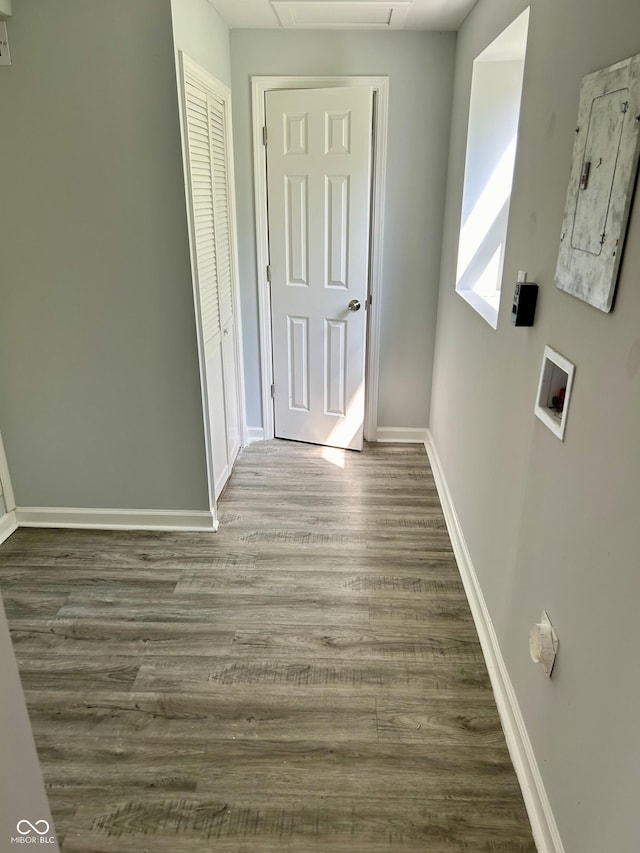 corridor featuring baseboards and wood finished floors