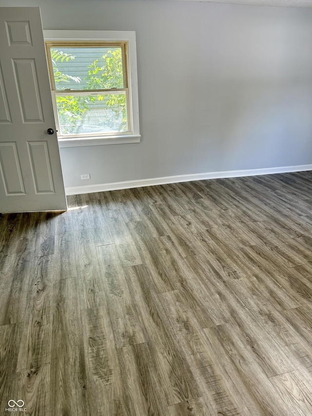 empty room with baseboards and wood finished floors