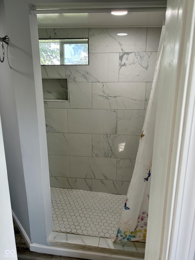 bathroom featuring a stall shower and baseboards