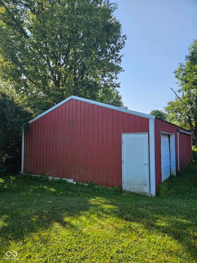 view of outdoor structure with a yard and a garage