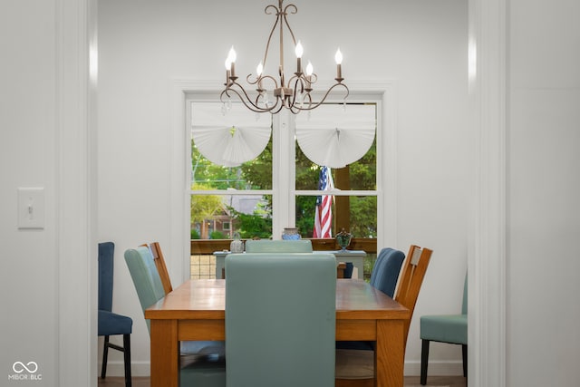 dining area featuring hardwood / wood-style flooring and a notable chandelier