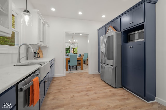 kitchen featuring a chandelier, light hardwood / wood-style flooring, stainless steel appliances, sink, and light stone countertops