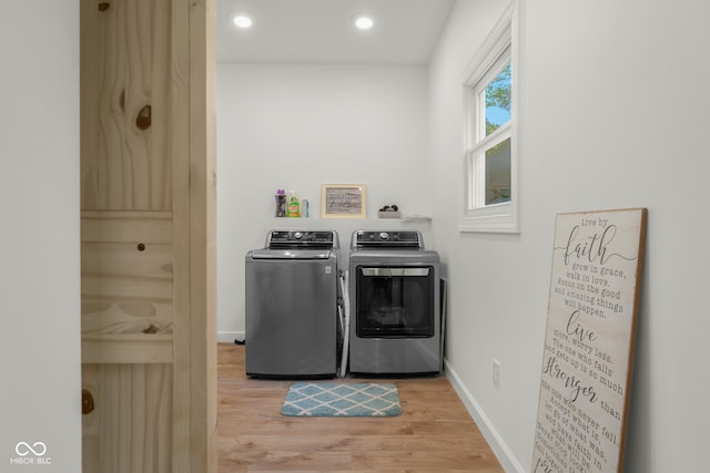 washroom with light hardwood / wood-style flooring and washer and clothes dryer