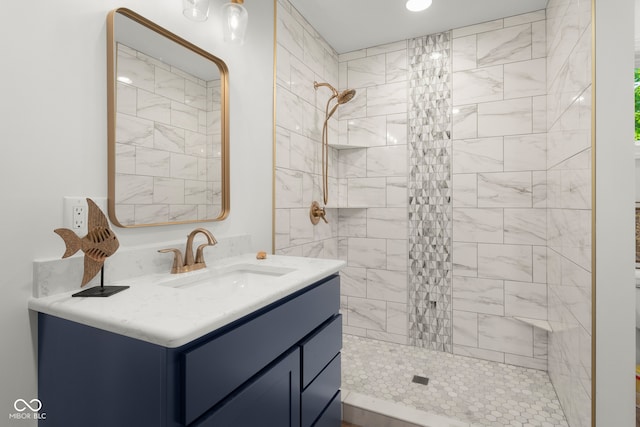 bathroom with tiled shower and vanity