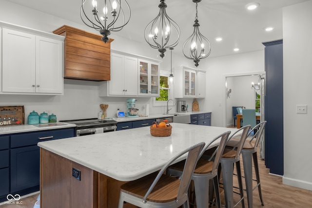 kitchen with a kitchen island, decorative light fixtures, light hardwood / wood-style floors, stainless steel range with electric stovetop, and white cabinets