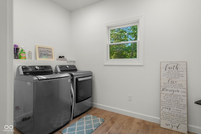 washroom with separate washer and dryer and light hardwood / wood-style flooring