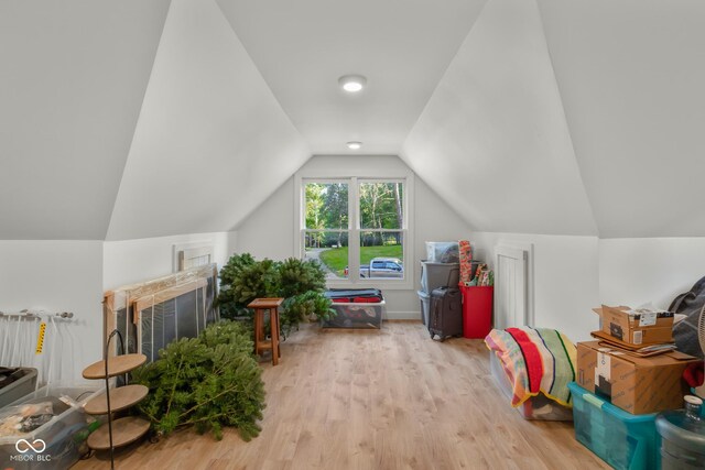 interior space featuring light wood-type flooring and vaulted ceiling