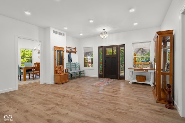 foyer entrance featuring a notable chandelier and light hardwood / wood-style floors