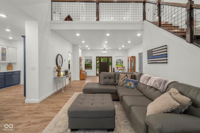 living room featuring a towering ceiling and light wood-type flooring