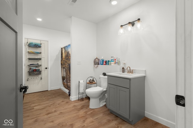 bathroom featuring vanity, toilet, a shower with shower curtain, and hardwood / wood-style flooring