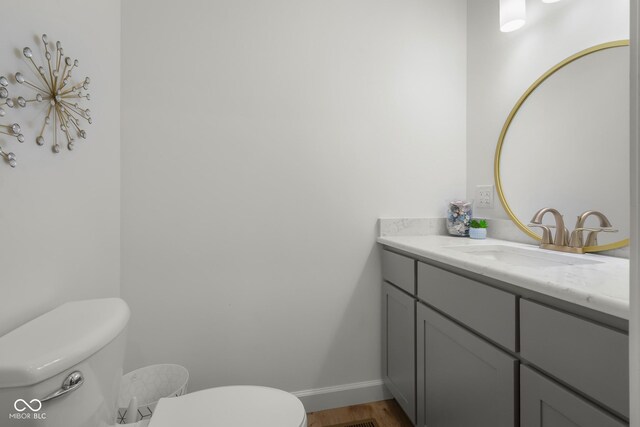 bathroom featuring wood-type flooring, toilet, and vanity