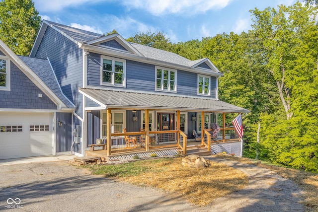 view of front of home with a shingled roof, aphalt driveway, covered porch, metal roof, and a garage