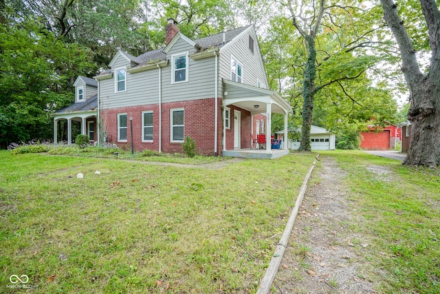 view of front facade with a front lawn, covered porch, and a garage