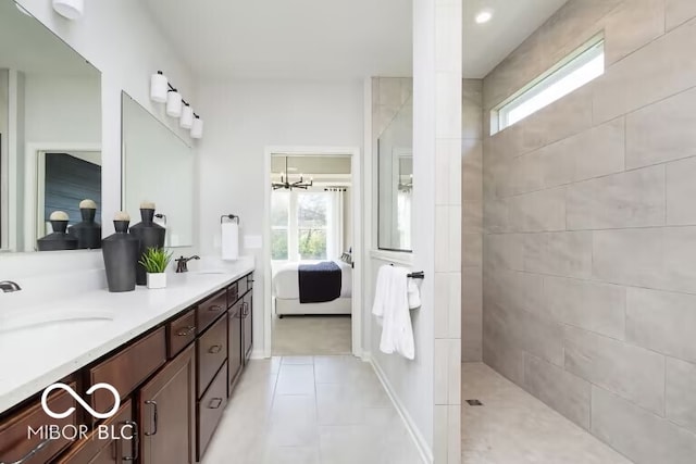 bathroom with a tile shower, tile patterned floors, plenty of natural light, and vanity