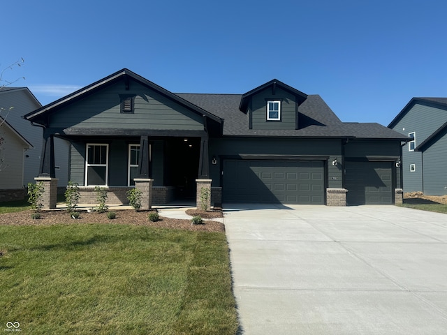 craftsman-style house with a garage, a front lawn, and covered porch