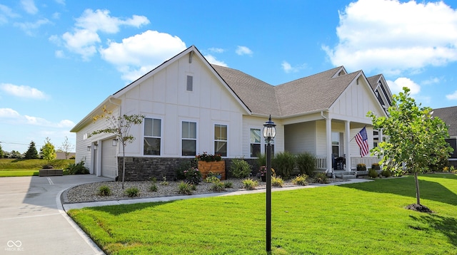 view of front facade with a garage, a porch, and a front lawn