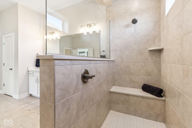 bathroom with a tile shower and vanity