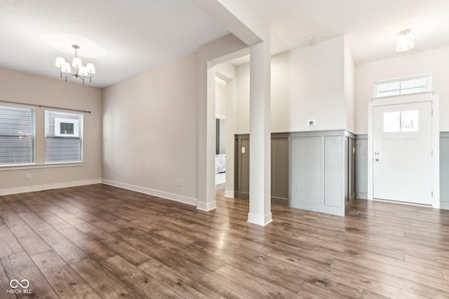 unfurnished living room with hardwood / wood-style flooring and a chandelier