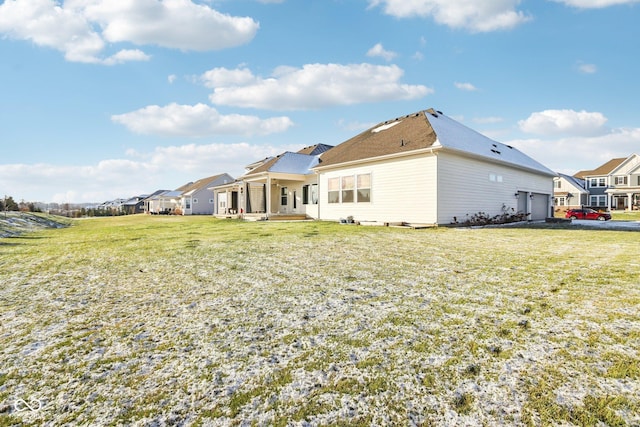 rear view of house featuring a garage and a yard