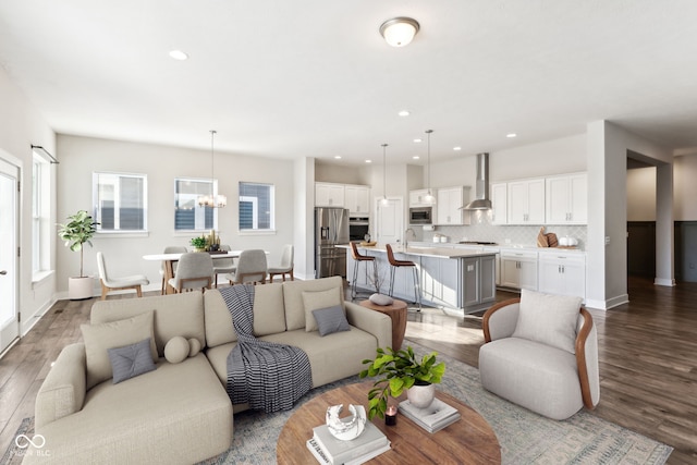 living room featuring sink, hardwood / wood-style flooring, and a notable chandelier