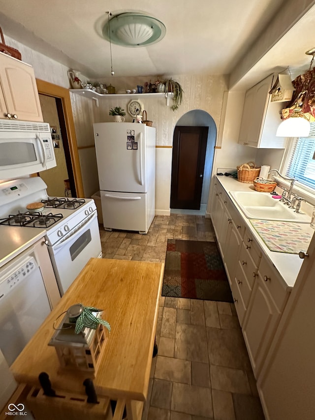 kitchen featuring white cabinetry, white appliances, and sink