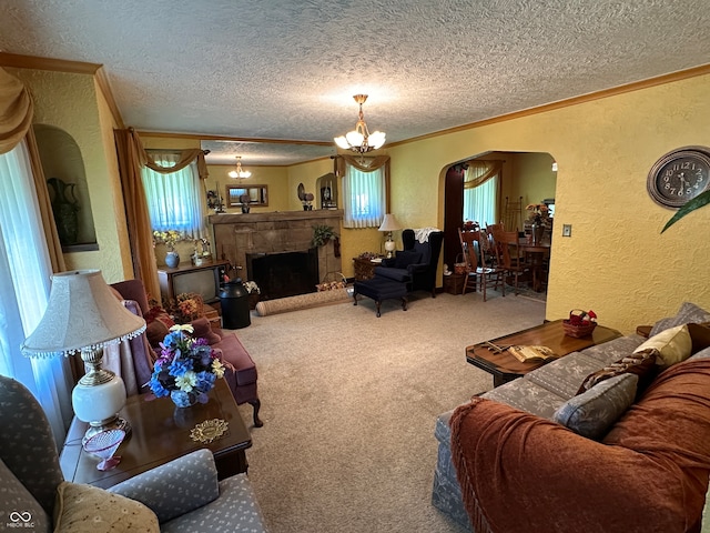 carpeted living room featuring ornamental molding, a textured ceiling, and an inviting chandelier