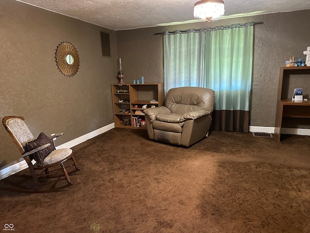 living area with a textured ceiling and dark colored carpet