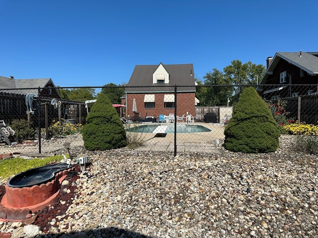 rear view of house featuring a fenced in pool and a patio area