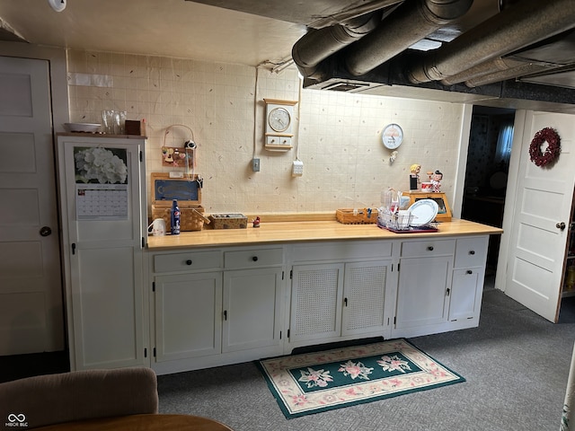 kitchen with dark carpet and white cabinets