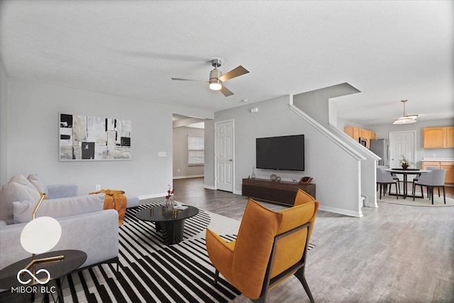 living room with ceiling fan, hardwood / wood-style floors, and a textured ceiling