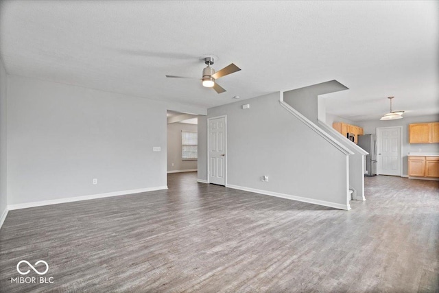 unfurnished living room featuring a textured ceiling, dark hardwood / wood-style floors, and ceiling fan